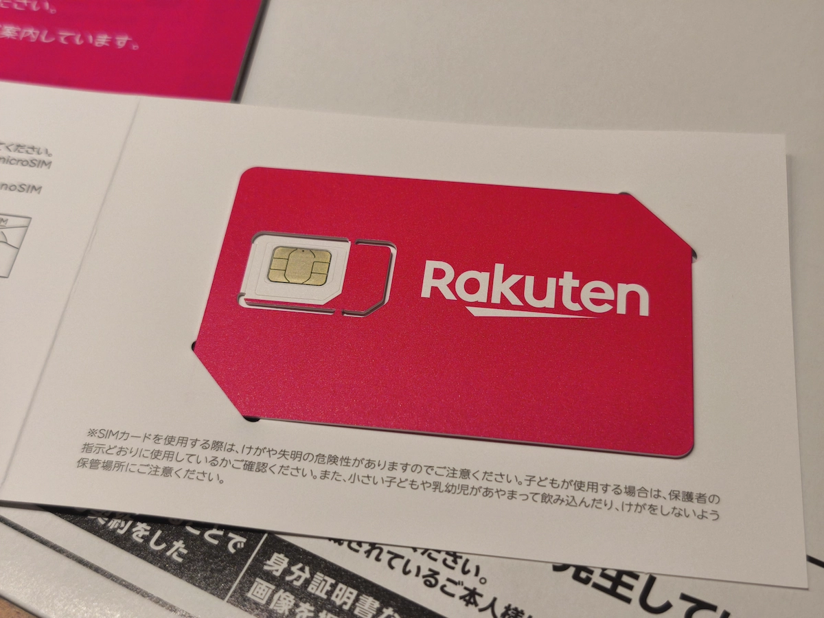 台紙にはめ込まれた楽天モバイルのピンク色のSIMカード。カードにはRakutenのロゴが大きく印刷され、安全上の注意書きが下部に記載されている。