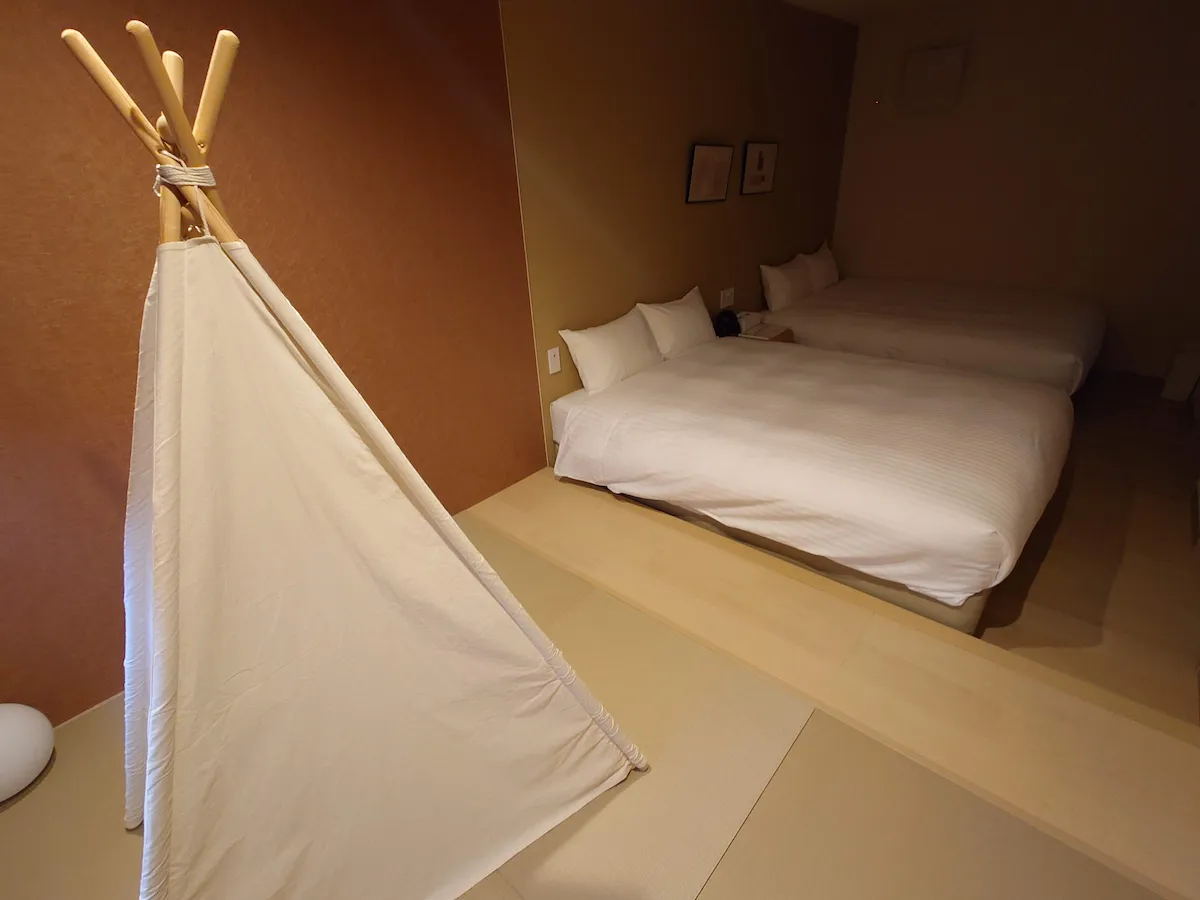 家族旅行で利用した宿泊先の寝室。ツインベッドの横に、子供が遊べる白色のティピーテントが設置されている。