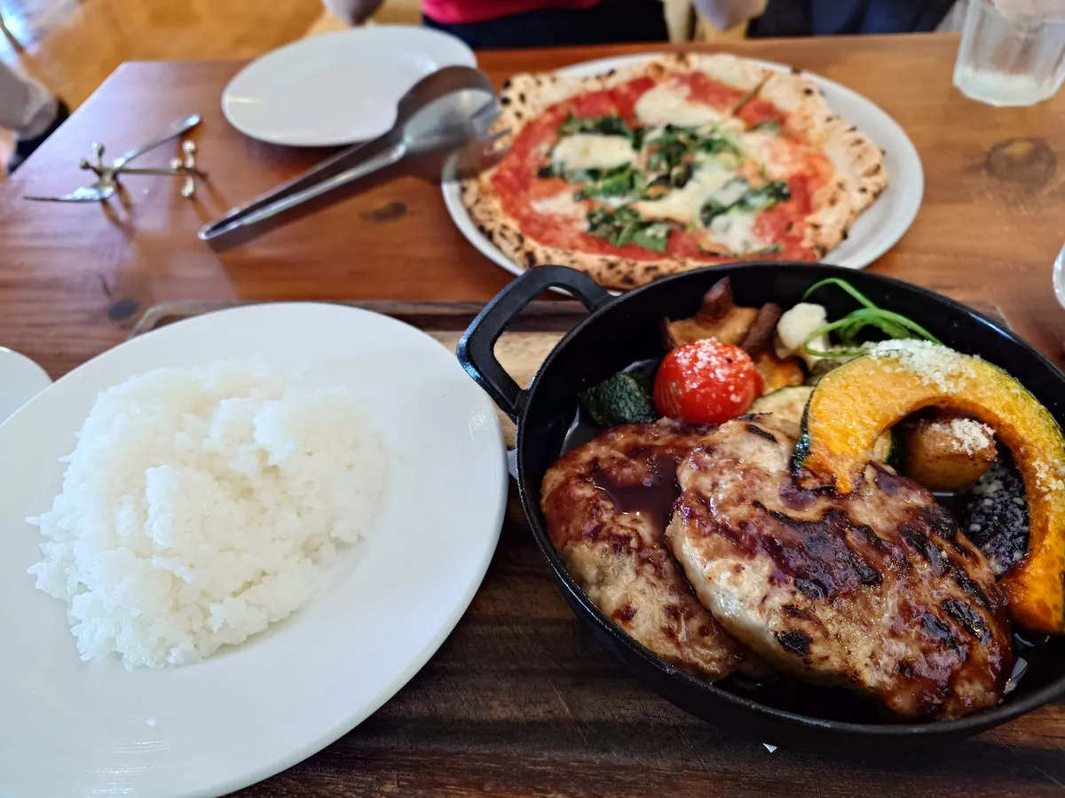 鉄鍋に入ったジューシーなハンバーグステーキとマルゲリータピザのランチセット。八ヶ岳の恵みを感じる食事。