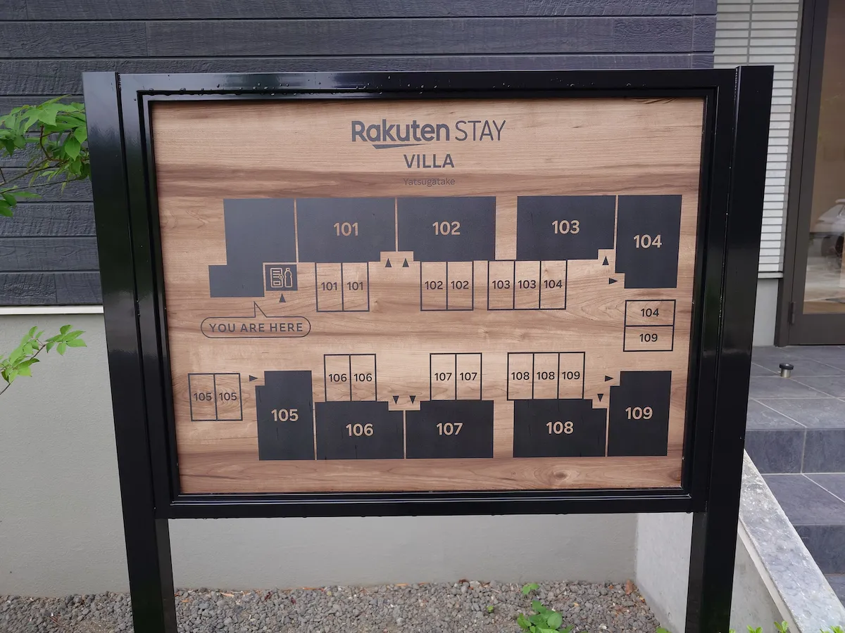 山梨県北杜市にある宿泊施設「Rakuten STAY VILLA 八ヶ岳」の施設案内図。木目調のおしゃれな看板に、全9室あるヴィラの配置が示されている。