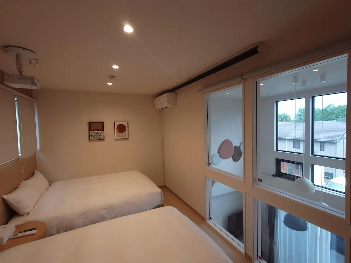 楽天STAY VILLA 八ヶ岳の寝室。リビングを見下ろせる内窓があり、天井には大画面で映像を楽しめるプロジェクターが設置されている。