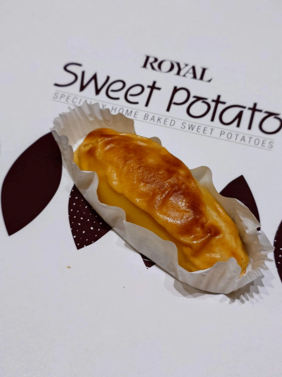 ROYALスイートポテトを化粧箱のロゴ上に配置。焼き色が美しい個包装スイーツをクローズアップ