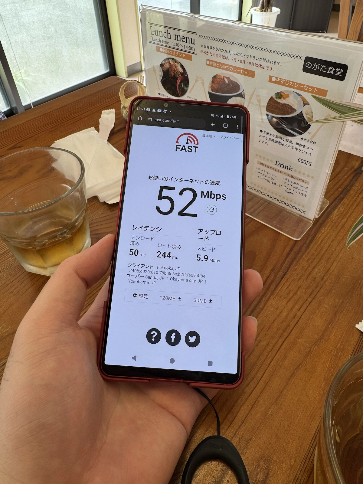 食堂テーブルでfast.com計測、下り52Mbps・レイテンシ50ms。店内の通信状況を確認